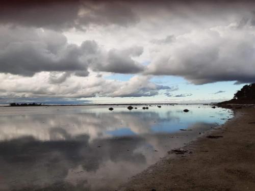 a reflection of the sky in the water on the beach at 6 person holiday home in Jægerspris in Jægerspris
