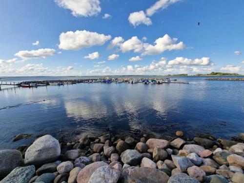 a large body of water with rocks and a pier at 7 person holiday home in Juelsminde-By Traum in Juelsminde