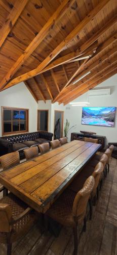 a large wooden table in a room with chairs at Apart Hotel Agua Escondida in San Martín de los Andes