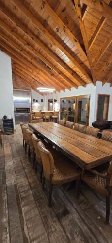a large wooden table and chairs in a room at Apart Hotel Agua Escondida in San Martín de los Andes