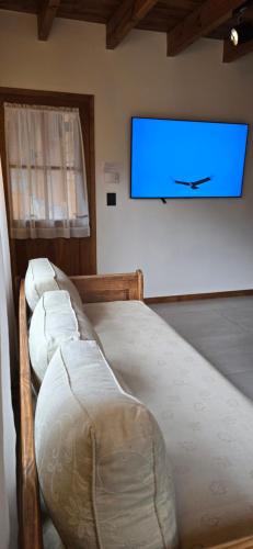 two beds in a room with a tv on the wall at Apart Hotel Agua Escondida in San Martín de los Andes