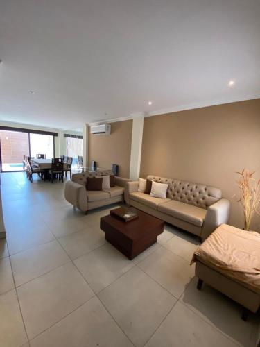 a large living room with couches and a table at Guayaquil Casa Paraiso in Guayaquil