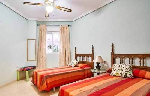 sypialnia z dwoma łóżkami i wentylatorem sufitowym w obiekcie Casa Luna con Piscina, 300m playa w mieście El Campello