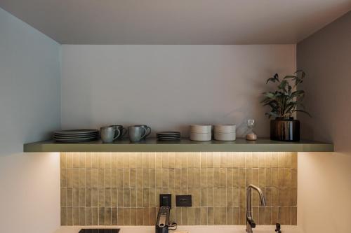 a kitchen with a sink and a shelf with dishes at Sereno Building in Medellín