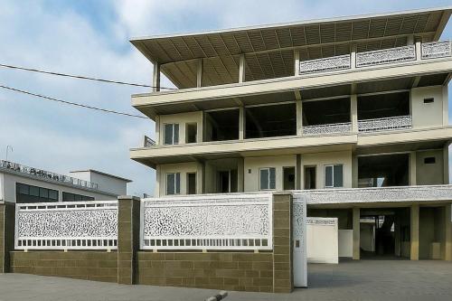 a large building with a white fence in front of it at Sazara Hotel Batu in Selecta