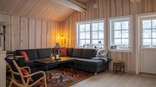 a living room with a couch and a table at Budor - Gråspetten 9 - 60 min fra OSL - Familiehytte - 3 soverom - 7 senger in Hamar