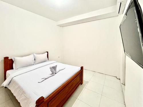 a bedroom with a bed and a flat screen tv at Sazara Hotel Batu in Selecta