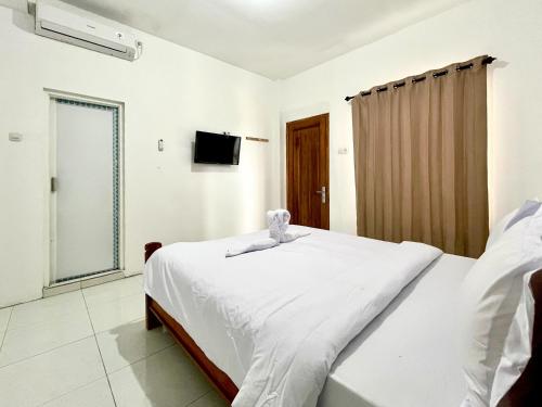 a bedroom with a bed and a television in it at Sazara Hotel Batu in Selecta