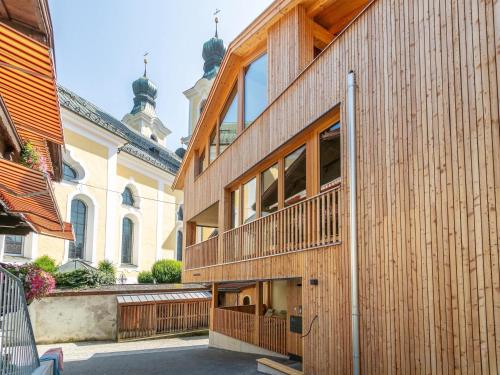 a wooden building with a balcony in front of a building at Hopfgarten Alpin Living Top 6 in Hopfgarten im Brixental