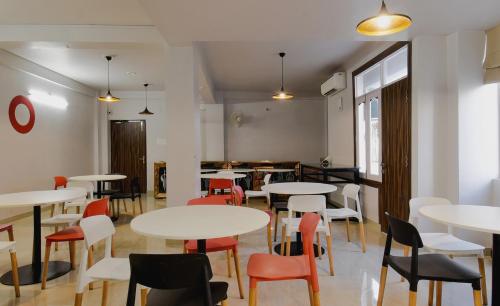 a restaurant with white tables and chairs and a room at Super Townhouse Vidya Vihar in Patna