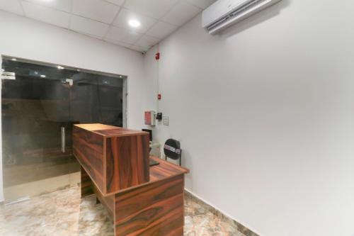 a room with a wooden desk and a large window at Hotel O CSRK in Ghaziabad