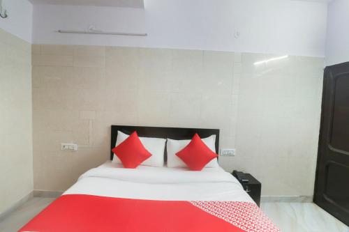 a bedroom with a bed with red pillows at Hotel O CSRK in Ghaziabad