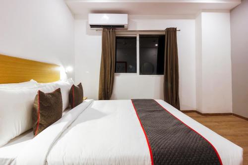 a bedroom with a large white bed in a room at Super Townhouse RCC Elite in Hyderabad