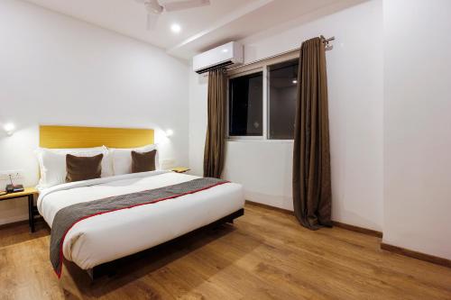 a hotel room with a bed and a window at Super Townhouse RCC Elite in Hyderabad