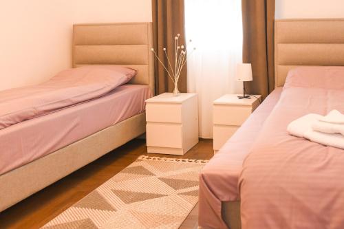 Un dormitorio con dos camas y dos mesitas de noche. en SleepAndGo, en Kraljevo