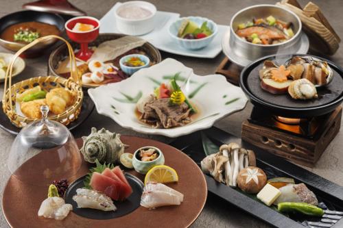 a table with many plates of food on it at KAMENOI HOTEL Chitamihama in Mihama