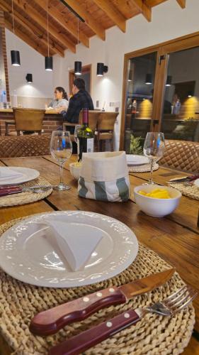 a wooden table with a white plate and fork and knife at Apart Hotel Agua Escondida in San Martín de los Andes