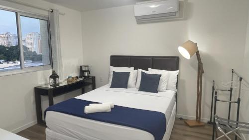 a bedroom with a large bed with blue and white pillows at Apto de luxo, requinte e lazer no coração de Belém in Belém