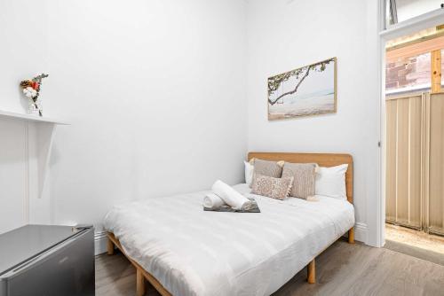 a bedroom with a bed with white walls at No Frill Economic Double Room - Ideally Located - Shared External Bathroom & Kitchen in Sydney