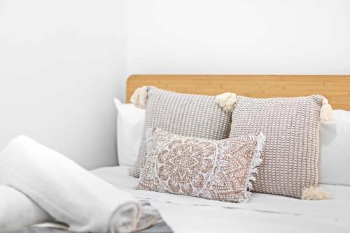a white bed with pillows and a white wall at No Frill Economic Double Room - Ideally Located - Shared External Bathroom & Kitchen in Sydney