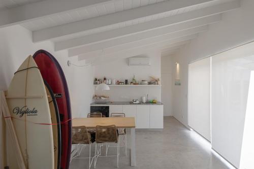 a dining room and kitchen with a surfboard on the wall at Ola Santa in Colonia Chapadmalal