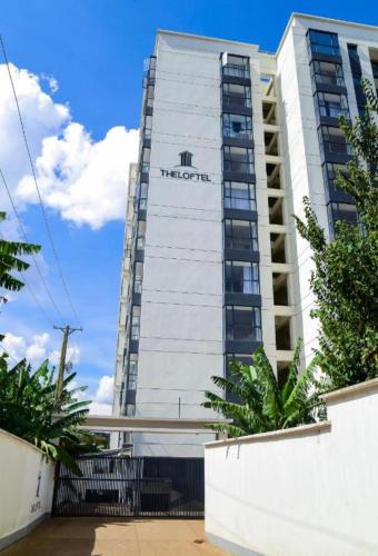 a tall white building with a sign on it at Niva house in Ruaka