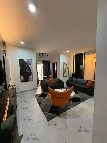 a large living room with couches and a television at Luxurious fully furnished 3 bedroom apartment in Ikate