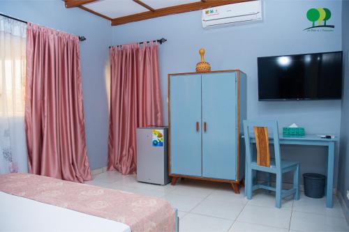 a bedroom with a cabinet and a desk and a chair at VILLA DE L'INTEGRATION in Ouagadougou