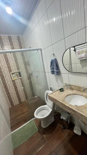 a bathroom with a shower and a toilet and a sink at Casa com dois quartos e piscina in Barreirinhas