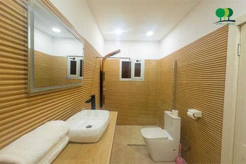 a bathroom with a white toilet and a sink at VILLA DE L'INTEGRATION in Ouagadougou