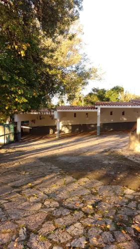 a park with two white buildings and trees at Ribera Sur Hotel - Los Algarrobos - Tanti in Tanti