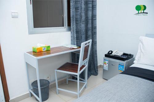 a desk with a chair next to a bed at VILLA DE L'INTEGRATION in Ouagadougou