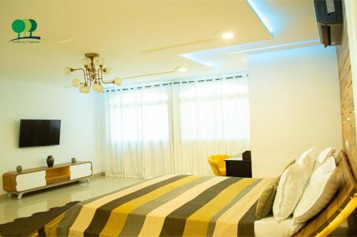 a bedroom with a bed and a tv on a wall at VILLA DE L'INTEGRATION in Ouagadougou