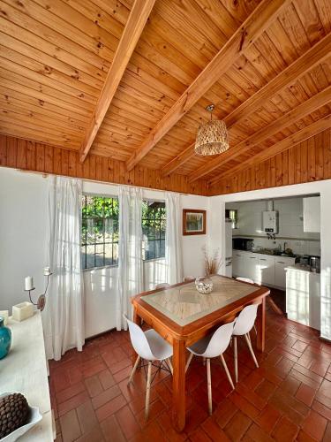 a dining room with a wooden ceiling and a table and chairs at Espectacular Casa en El Canelo, Algarrobo in Algarrobo