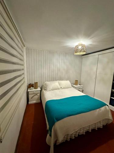 a bedroom with a large bed with a blue blanket at Espectacular Casa en El Canelo, Algarrobo in Algarrobo
