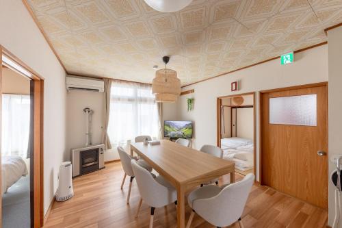 a dining room with a table and chairs at Niko House Furano in Furano