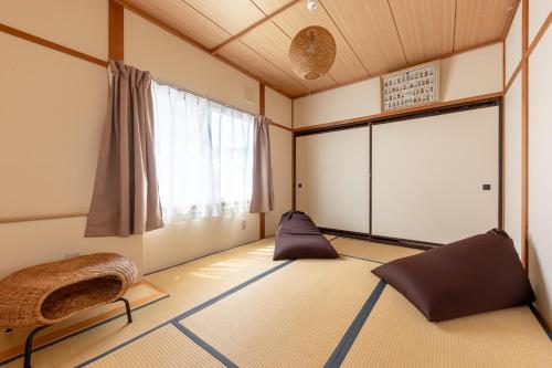 an empty room with a large window and a bed at Niko House Furano in Furano