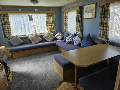 a living room with a couch and a table at Cosy caravan in Skegness