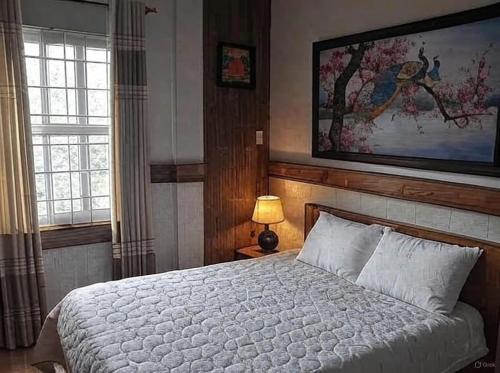 a bedroom with a bed and a painting on the wall at Hong's family house in Ấp Ngọc Hải