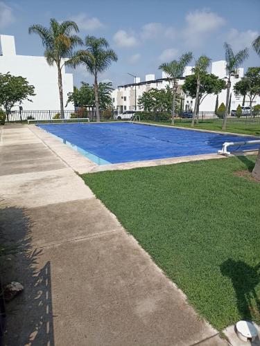 a large blue swimming pool next to a sidewalk at Hermosa casa en cluster privado in Laurel de Lagunillas