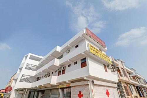 a white building with a yellow sign on it at Hotel O Fine Stay Guest House in Bhauli
