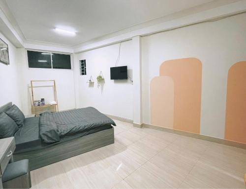 a bedroom with a bed and a tv in it at Lucia Home Đà Lạt in Da Lat