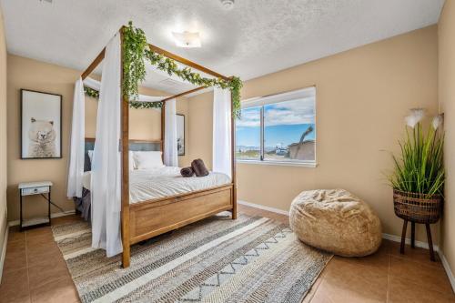 a bedroom with a canopy bed and a window at Jt Desert Dwelling in Twentynine Palms