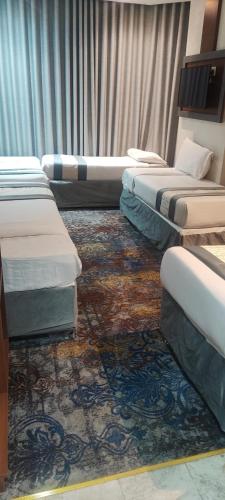a room with four beds and a rug at محبس الجن in Al Khansāk