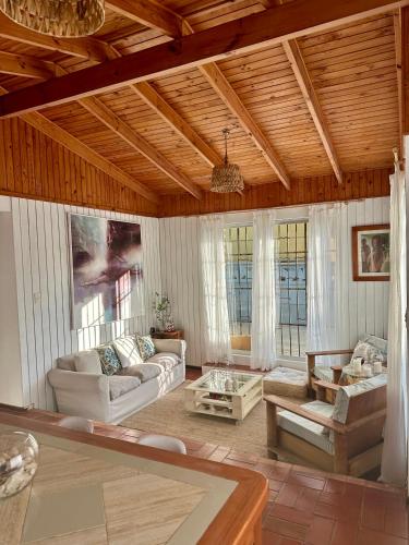 a living room with white furniture and a wooden ceiling at Espectacular Casa en El Canelo, Algarrobo in Algarrobo