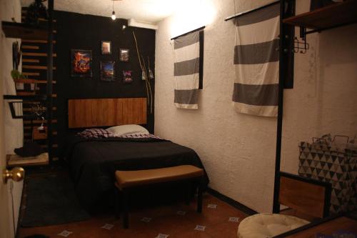 a small bedroom with a bed and a chair at Vintage Apartment with Balcony & Terrace in Antigua Guatemala