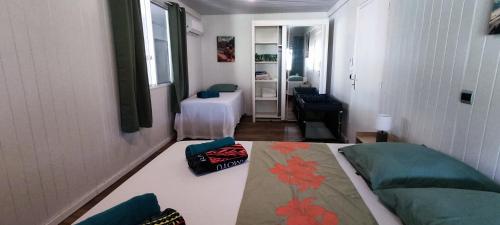a small room with a bed and a living room at Fare Coco Tiaré - Jardin Tropical Piscine - Moorea in Afareaitu