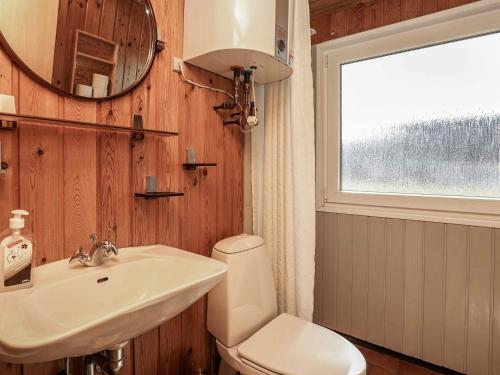 a bathroom with a sink and a toilet and a mirror at 6 person holiday home in Hvide Sande-By Traum in Hvide Sande