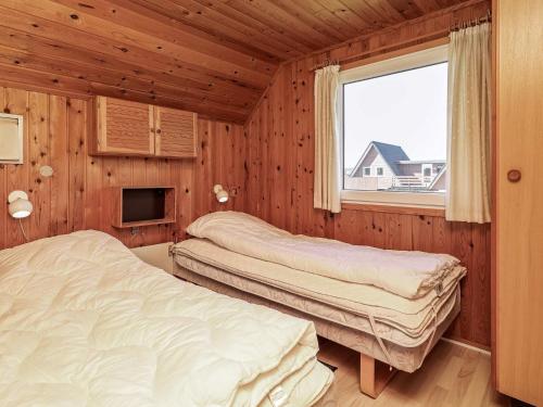 two beds in a room with a window at 6 person holiday home in Hvide Sande-By Traum in Hvide Sande