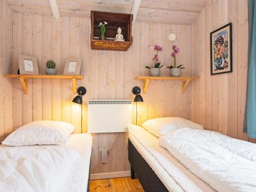 deux lits dans une chambre aux murs en bois dans l'établissement 4 person holiday home in Hemmet-By Traum, à Hemmet